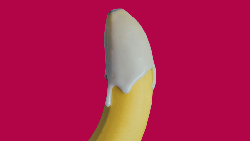 Image of a yellow banana topped with cream against a hot pink background.
