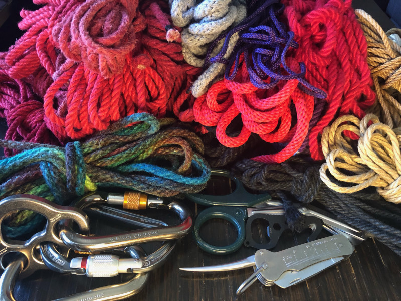 A colorful bundle of rope with carabiners, safety shears, and a marlin spike.