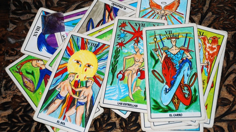An assortment of tarot cards spread on a table.